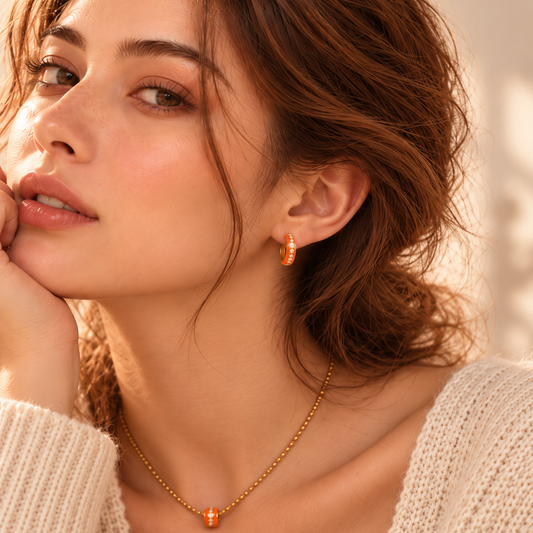     Model trägt Vivikiu Creolen mit orangefarbener Emaille und Zirkonia
